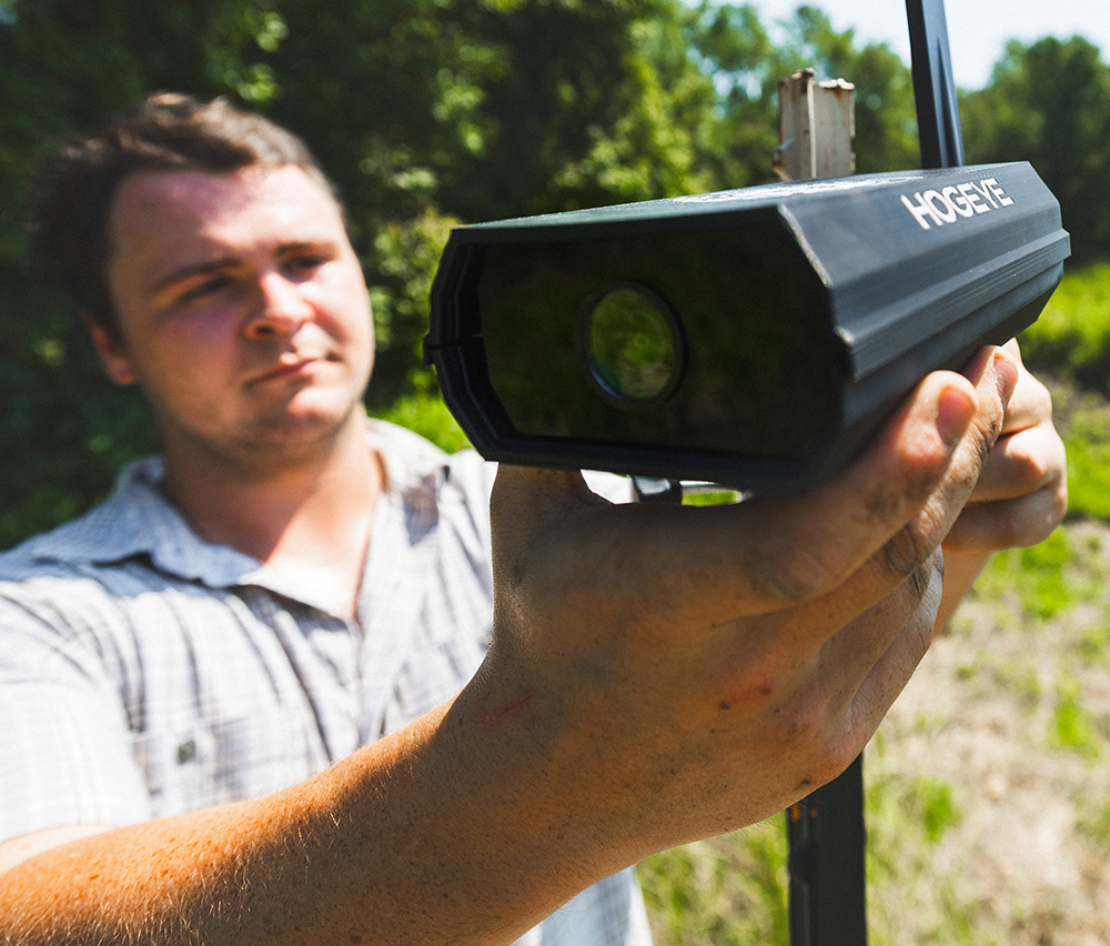 Man holding a HogEye camera device outdoors